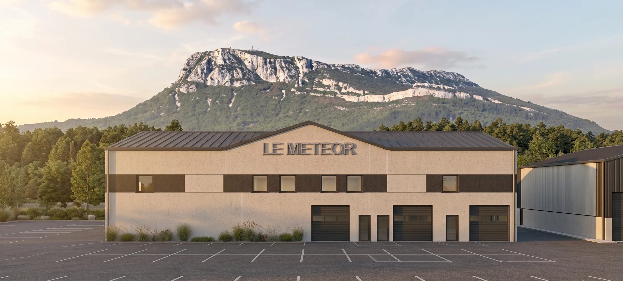 Façade du Météor — panneaux béton clairs, bandeau noir, portes sectionnelles